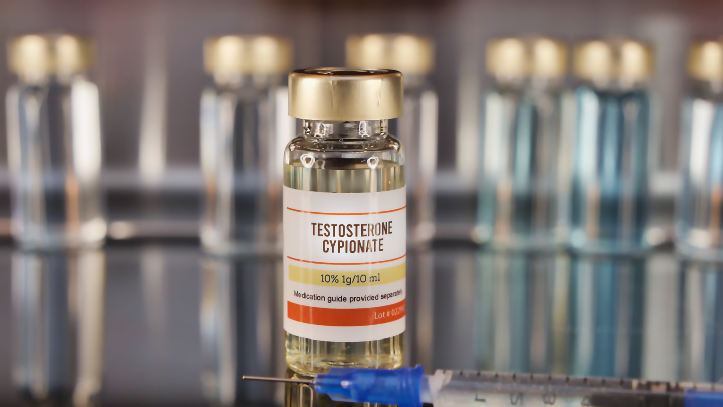 Vial of Testosterone Cypionate with syringe on a stainless steel background.